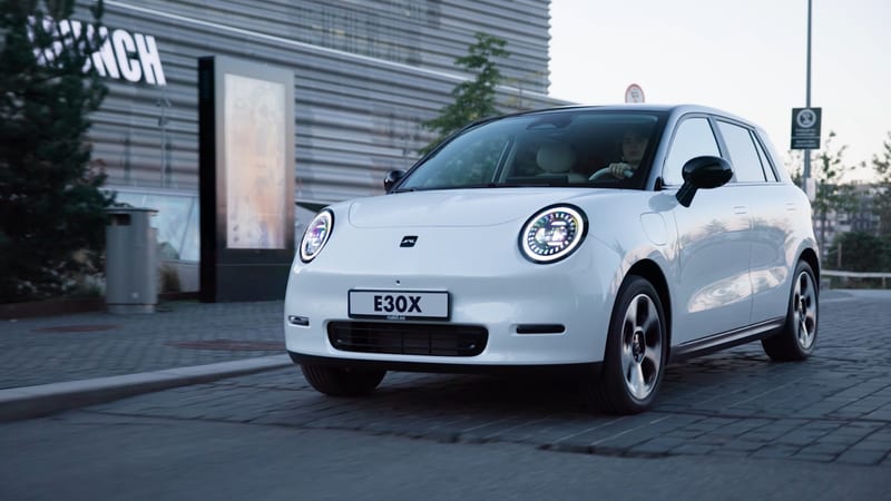 JAC E30X von vorne vor moderner Architektur